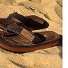 Sandalen voor buitengebruik met leren uitstraling op zandstrand.