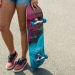 Kleurijke skateboard met blauwe wielen en grafisch design, perfect voor buitenplezier.
