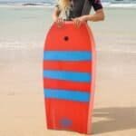 Kleurrijke bodyboard op het strand klaar voor watersportplezier.