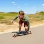 Snelle man op skateboard in buitenlucht, genietend van de zon en de wind tijdens het skateboarden.