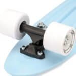 Wieltje voor skateboard met witte wielen en zwarte as, bevestigd op blauw deck.