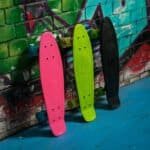 Kleurrijke skateboards aan een muur in een urban skatepark.