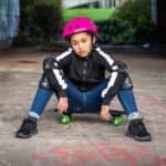 Verkeershelm voor kids en skateboard, stoer en veilig, kind op skateboard met beschermingskleding, outdoor activiteiten voor kinderen, skateboard en veiligheidsuitrusting.
