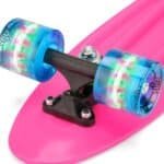 Kleurrijke skateboard wielen en trucks op roze skateboarddeck voor buitenplezier.