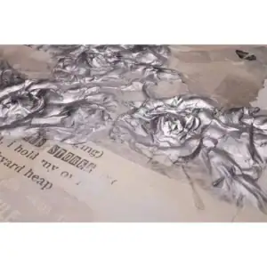 Een close-up van gekreukeld aluminiumfolie met document eronder.