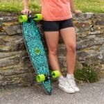 Skateboard met levendige blauwe patronen en neon groene wielen, klaar voor ontspannende buitenritten.