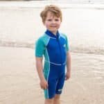 Kinder in een zwemshort op het strand, klaar voor waterplezier.