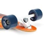 Relatief nieuwe skate met zwarte wielen en witte trucks op een houten dek.
