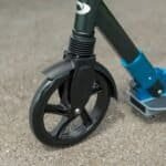 Klein kinder scooters met zwarte wielen en blauwe frame-onderdelen voor buitenplezier.