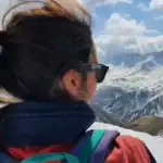 Bergenlandschap, vrouw in sunglasses met mountainview, sneeuw en wolken.