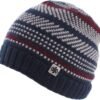 Warme gebreide wintermuts met kleurrijk patroon en metalen logo detail.