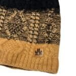 Warm wollen muts met gebreide patroon en leerlabel voor outdoor activiteiten.