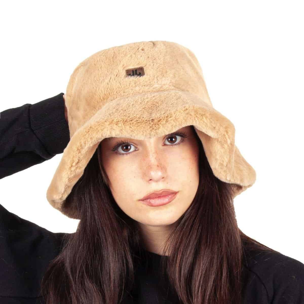 Knuffelige beige teddy pet met bandje op hoofd.