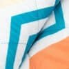 Modern waterbestendige outdoor kussen met geometrisch blauw en oranje patroon.