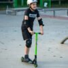 Scooter voor kinderen met beschermkleding op het skatepark.