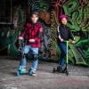 Scooters en helmen voor kinderen, klaar voor buitenavontuur, tegen graffiti muur.