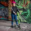 Snelle scooter voor kinderen met bescherming en helmet, klaar voor buitenavontuur.